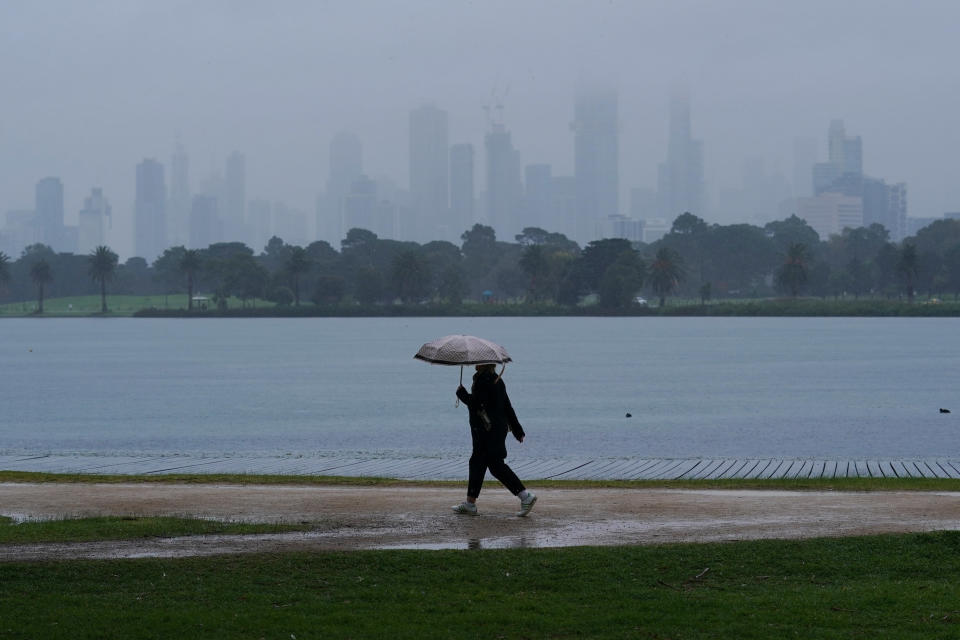 People walk in isolation as heavy rain begins to fall in Melbourne on Wednesday. Source: AAP