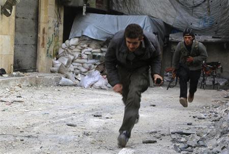 A man and a rebel fighter run as they avoid snipers loyal to Syria's President Bashar al-Assad stationed at Aleppo's al-Ramoussa highway April 9, 2014. REUTERS/Mahmoud Hebbo