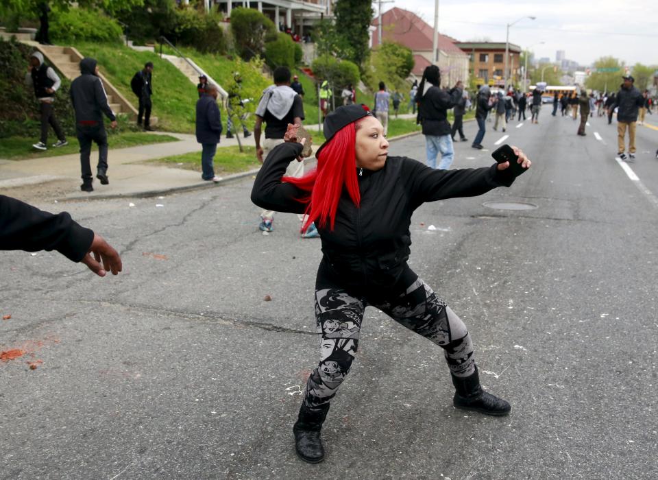 Demonstrators throw rocks at Baltimore police during clashes in Baltimore, Maryland April 27, 2015. Several Baltimore police officers were injured on Monday in violent clashes with young people after the funeral of Freddie Gray, a black man who died in police custody, and local law enforcement warned of a threat by gangs. REUTERS/Shannon Stapleton