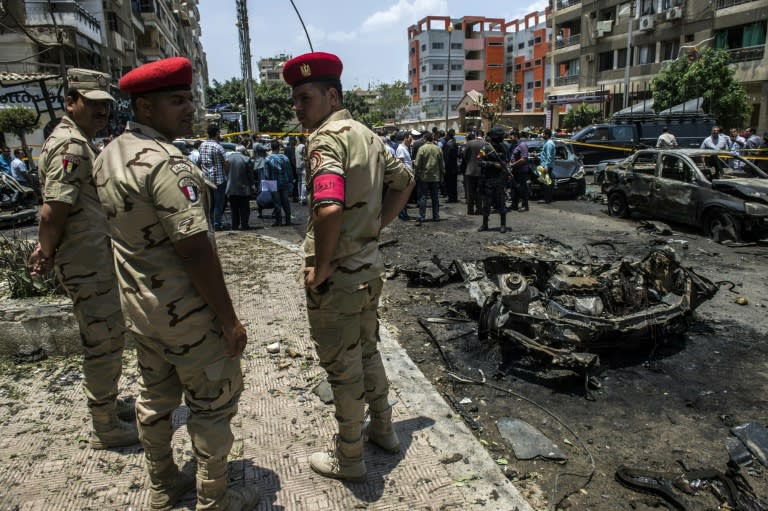 Egyptian security forces stand guard as people gather at the site of a bomb attack that killed the state prosecutor in Cairo, on June 29, 2015