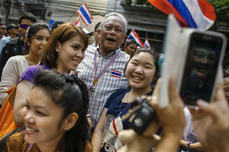 Protest leader Suthep Thaugsuban (C) poses for a photo with supporters during a rally in central of Bangkok March 24, 2014. REUTERS/Athit Perawongmetha