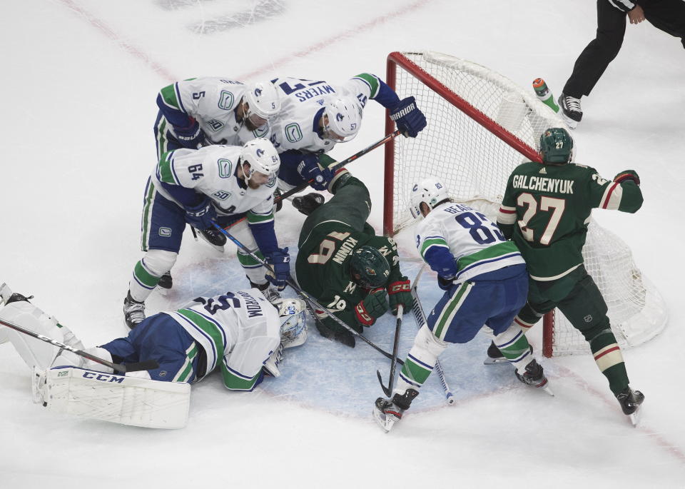 Vancouver Canucks goalie Jacob Markstrom (25) makes the save as the Vancouver Canucks and the Minnesota Wild scramble in the crease during the second period of an NHL hockey playoff game Thursday, Aug. 6, 2020 in Edmonton, Alberta. (Jason Franson/The Canadian Press via AP)