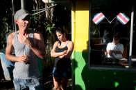 Cubans migrants stand outside a border post where an immigration offical looks on, as they wait for the opening of the border between Costa Rica and Nicaragua in Penas Blancas, Costa Rica November 17, 2015. More than a thousand Cuban migrants hoping to make it to the United States were stranded in the border town of Penas Blancas, Costa Rica, on Monday after Nicaragua closed its border on November 15, 2015 stoking diplomatic tensions over a growing wave of migrants making the journey north from the Caribbean island. REUTERS/Oswaldo Rivas