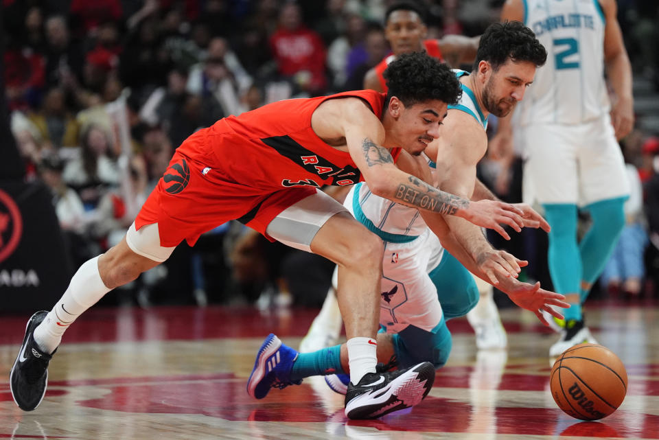Charlotte Hornets' Vasilije Micić, right, and Toronto Raptors guard D.J. Carton (3) battle for a loose ball during the second half of an NBA basketball game in Toronto on Sunday, March 3, 2024. (Frank Gunn/The Canadian Press via AP)
