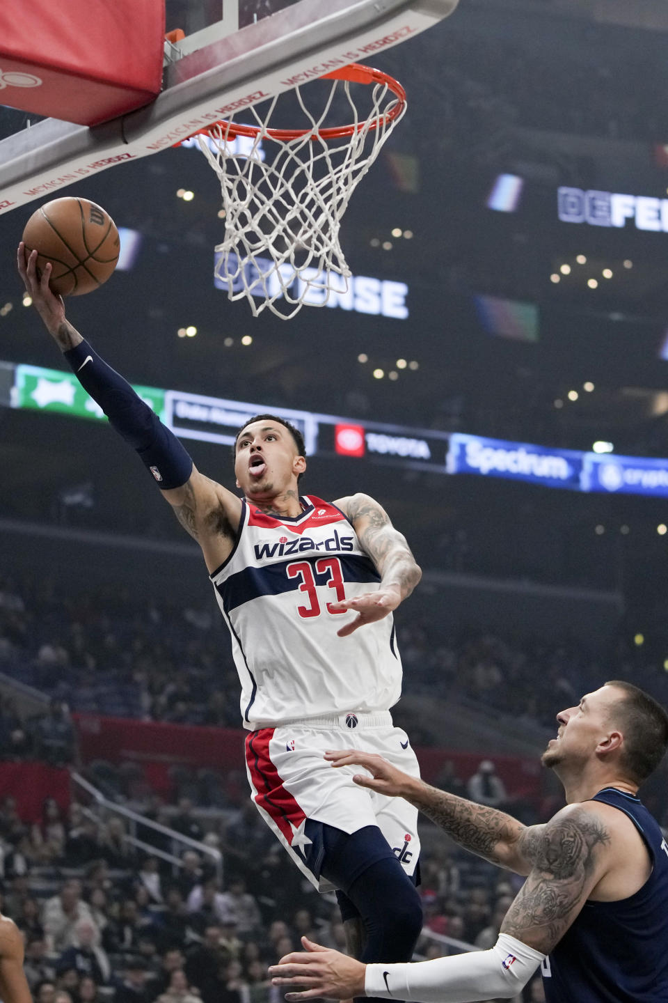 Washington Wizards forward Kyle Kuzma, left, shoots against Los Angeles Clippers center Daniel Theis during the first half of an NBA basketball game Friday, March 1, 2024, in Los Angeles. (AP Photo/Ryan Sun)