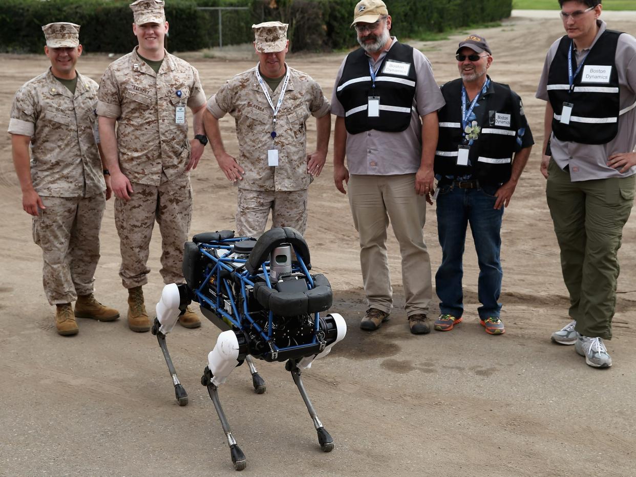 United States Marines and representatives from Boston Dynamics look at Spot, a four-legged robot designed for indoor and outdoor operation, during the Defense Advanced Research Projects Agency Robotics Challenge at the Fairplex June 5, 2015 in Pomona, California. Organized by DARPA, the Pentagon's science research group, 24 teams from around the world are competing for $3.5 million in prize money that will be awarded to the humanoid robots that best respond to natural and man-made disasters.