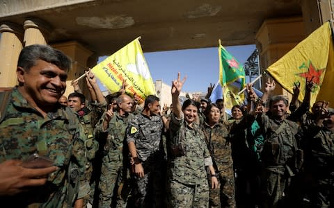 Fighters of Syrian Democratic Forces gesture the "V" sign in Raqqa, Syria - Credit: Reuters