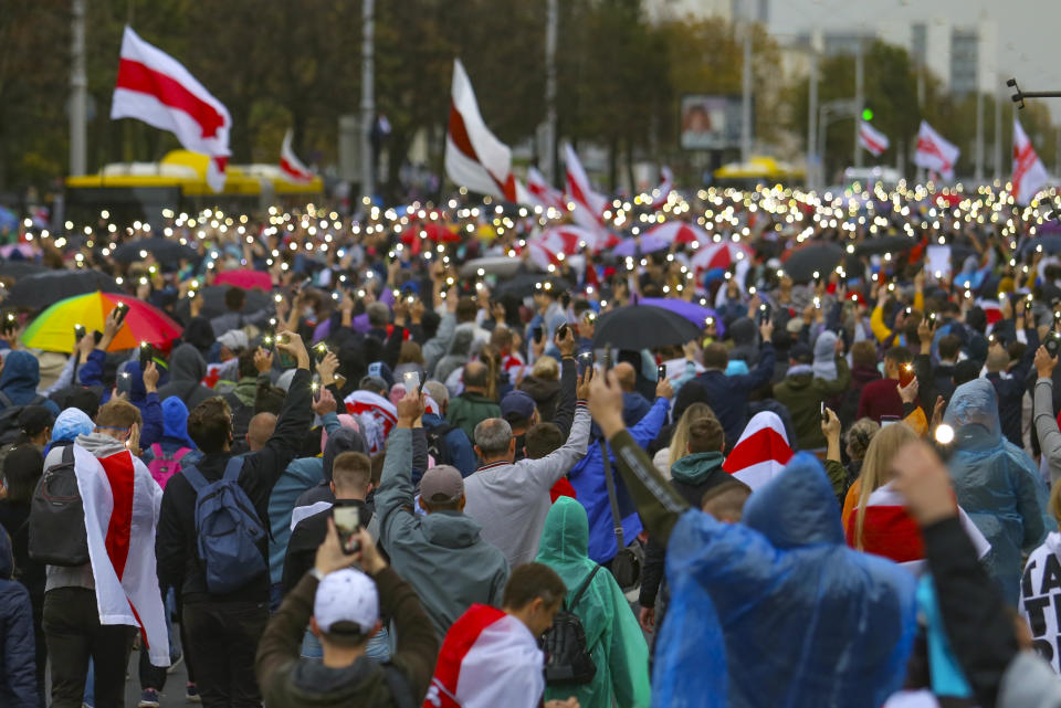 Demonstrators light their cell phones during an opposition rally to protest the official presidential election results in Minsk, Belarus, Sunday, Sept. 27, 2020. Tens of thousands of demonstrators marched in the Belarusian capital calling for the authoritarian president's ouster, some wearing cardboard crowns to ridicule him, on Sunday as the protests that have rocked the country marked their 50th consecutive day. (AP Photo/TUT.by)