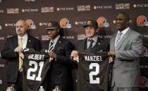 Cleveland Browns head coach Mike Pettine, left, helps cornerback Justin Gilbert display his jersey and general manager Ray Farmer, right, assists quarterback Johnny Manziel during a news conference at the NFL football team's facility in Berea, Ohio Friday, May 9, 2014. The Browns selected Gilbert with the eighth pick and Manziel with the 22nd pick in Thursday night's draft. (AP Photo/Mark Duncan)