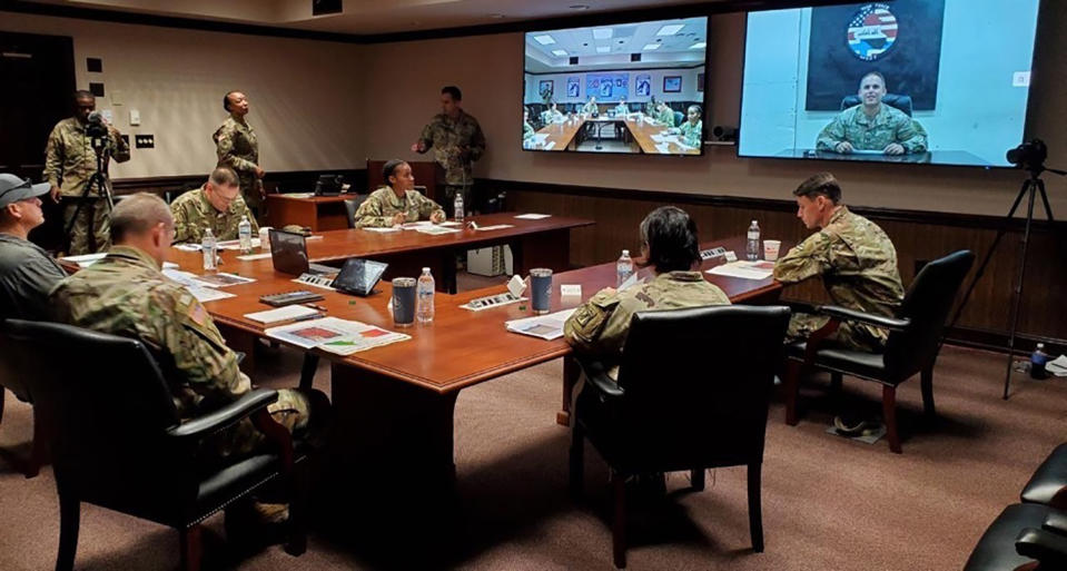 In this image provided by the U.S. Army, panelists listen to a U.S. Army soldier pitch his idea during the inaugural Dragon Innovation Challenge at Fort Bragg, N.C., on Tuesday, Oct. 27, 2020. The Shark Tank like competition is aimed at sourcing new ideas from untapped areas of the Army. (U.S. Army via AP)