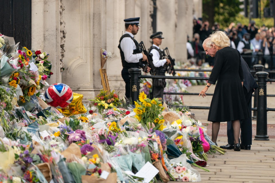 King Charles III and the Queen look at flowers outside Buckingham Palace, London after travelling from Balmoral following the death of Queen Elizabeth II on Thursday. Picture date: Friday September 9, 2022.