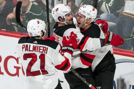 Nov 20, 2017; Saint Paul, MN, USA; New Jersey Devils defenseman John Moore (2) celebrates his goal with forward Adam Henrique (14) and forward Kyle Palmieri (21) during overtime against the Minnesota Wild at Xcel Energy Center. Brace Hemmelgarn-USA TODAY Sports