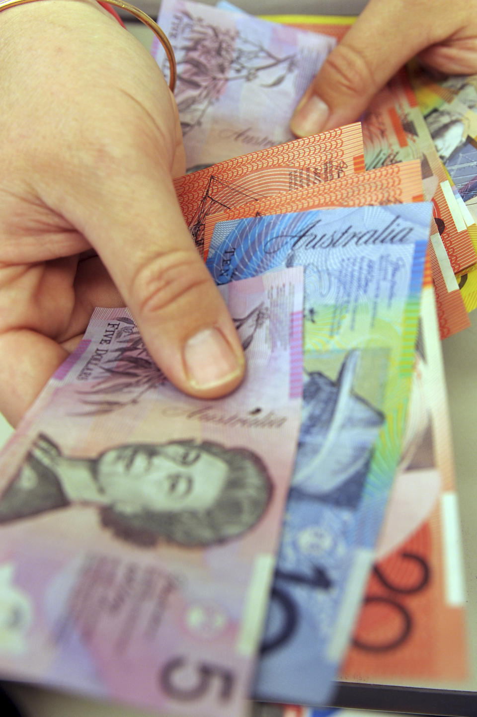 Australian banknotes are being counted in Canberra, Australia, May 1, 2009. Australia is removing the British monarchy from its bank notes. The nation's central bank said Thursday, Feb. 2, 2023, its new $5 bill would feature an Indigenous design rather than an image of King Charles III. But the king is still expected to appear on coins. (Alan Porritt/AAP Image via AP)