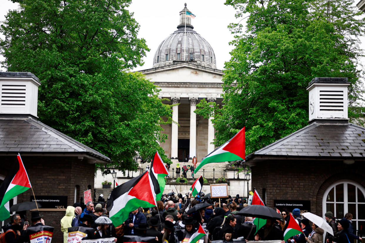 People hold placards and wave Palestinian flags. (Benjamin Cremel / AFP via Getty Images)