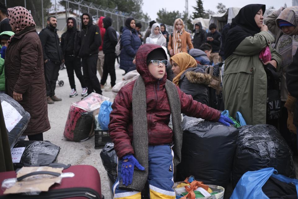 Refugees and migrants wait to leave from Moria refugee camp and go to the mainland Greece, on the northeastern Aegean island of Lesbos, Greece, on Tuesday, Jan. 21, 2020. Some businesses and public services on the eastern Aegean island are holding a 24-hour strike on Wednesday to protest the migration situation, with thousands of migrants and refugees are stranded in overcrowded camps in increasingly precarious conditions.(AP Photo/Aggelos Barai)