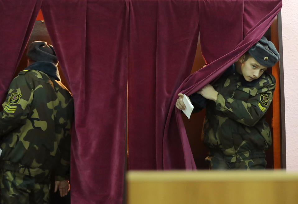 Belarus' Army servicemen prepare to cast his ballot a polling station during parliamentary elections, in Minsk, Belarus, Sunday, Nov. 17, 2019. (AP Photo/Sergei Grits)