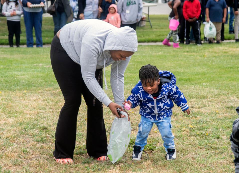 There-year-old Jayceon Madison is helped by his mother Cheryl Daniel at the Easter egg hunt at Nancy Patron Park in south Stockton on Thursday, April 14, 2022. The Sierra Vista Housing Resident Council held it's annual egg hunt after 2 years of cancelations due to the COVID-19 pandemic. 