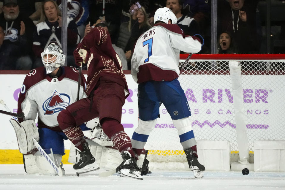 Arizona Coyotes center Travis Boyd scores a goal against Colorado Avalanche goaltender Alexandar Georgiev, left, as Avalanche defenseman Devon Toews (7) watches the puck during the second period of an NHL hockey game Thursday, Nov. 30, 2023, in Tempe, Ariz. (AP Photo/Ross D. Franklin)