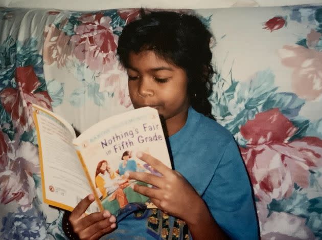 The author, age 8, pretending to read a book. (Photo: Courtesy of Nandini Maharaj)