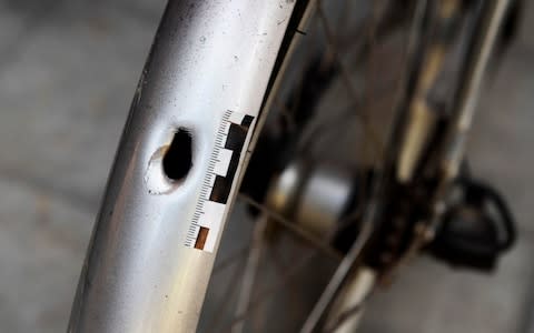  A bullet hole is seen at a bicycle at the site  - Credit: AFP