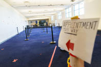 A sign points the way to a check-in area at a coronavirus mass-vaccination site at the former Citizens Bank headquarters in Cranston, R.I., Thursday, June 10, 2021. The U.S. is confronted with an ever-growing surplus of COVID-19 vaccines, looming expiration dates and stubbornly lagging demand at a time when the developing world is clamoring for doses to stem a rise in infections. (AP Photo/David Goldman)