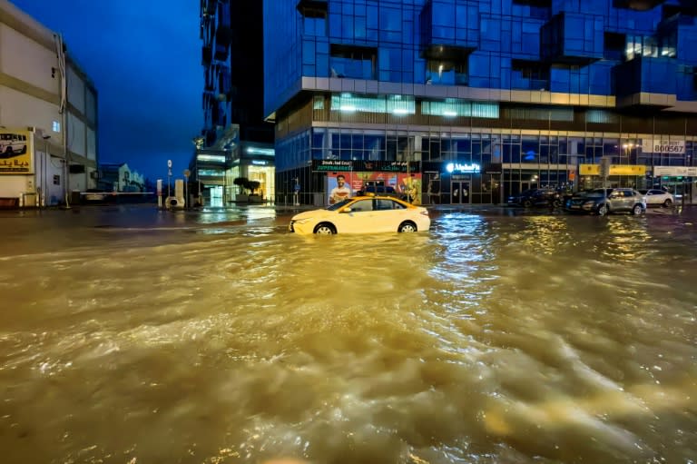 Un taxi traverse une rue inondée après des fortes pluies à Dubaï, le 17 avril 2024 (Giuseppe CACACE)