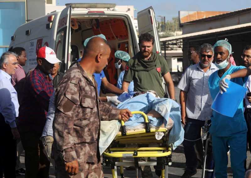 Paramedics assist a Turkish worker injured in an explosion in Afgoye town, before he boards a Turkish military cargo plane at the Aden Abdulle International Airport in Mogadishu