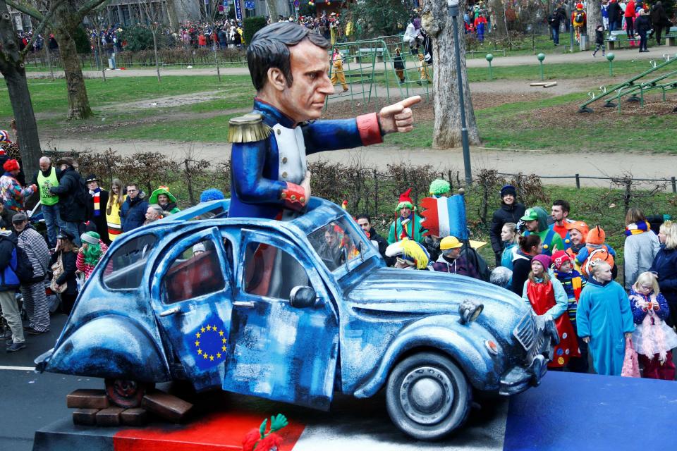 <p>Auch Frankreichs Staatschef darf im bunten Karnevalstreiben nicht fehlen: Er wird auf einem EU-blauen Citroën chauffiert und als Napoleon Bonaparte dargestellt. Die Plattform, auf der der Wagen steht, trägt wiederum die französischen Nationalfarben. (Bild: REUTERS/Ralph Orlowski) </p>