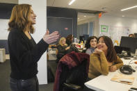 Jessica Coen, left, executive editor at The News Movement (TNM), a social media news operation re-imagined for Gen-Z consumers, chats with reporters at TNM offices on Wednesday, March 1, 2023, in New York. TNM uses a staff of reporters with an average age of 25 to make tailored news content for sites like TikTok, Instagram, YouTube and Twitter. (AP Photo/Bebeto Matthews)