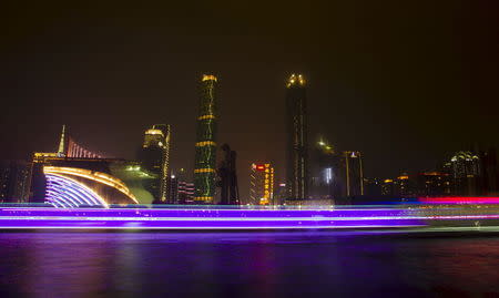 A long exposure picture of boats passing by a business area along the Pearl River in Guangzhou, Guangdong province, in this March 22, 2014 file photo. REUTERS/Alex Lee/Files