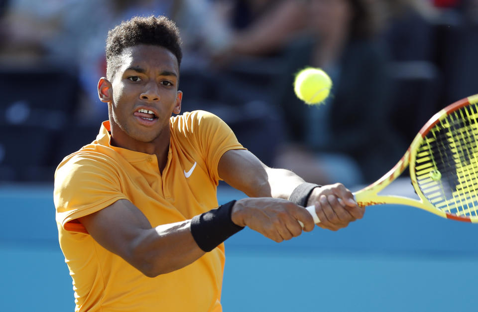 Felix Auger-Aliassime of Canada returns the ball to Feliciano Lopez of Spain during their men's singles semifinal match at the Queens Club tennis tournament in London, Saturday, June 22, 2019. (AP Photo/Alastair Grant)