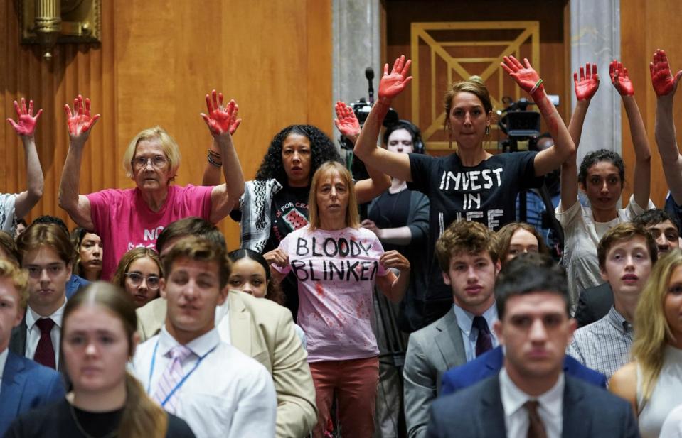 PHOTO: Protesters hold up 'bloody hands' as Secretary of State Antony Blinken testifies before a Senate Foreign Relations Committee hearing on Capitol Hill in Washington, May 21, 2024. (Kevin Lamarque/Reuters)