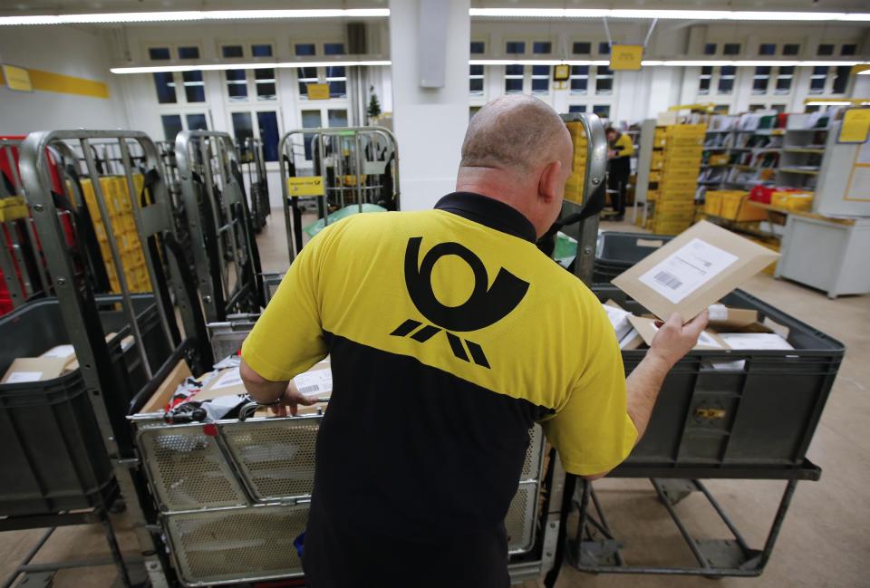 A postman of Deutsche Post sorts mail at a sorting office in Berlin