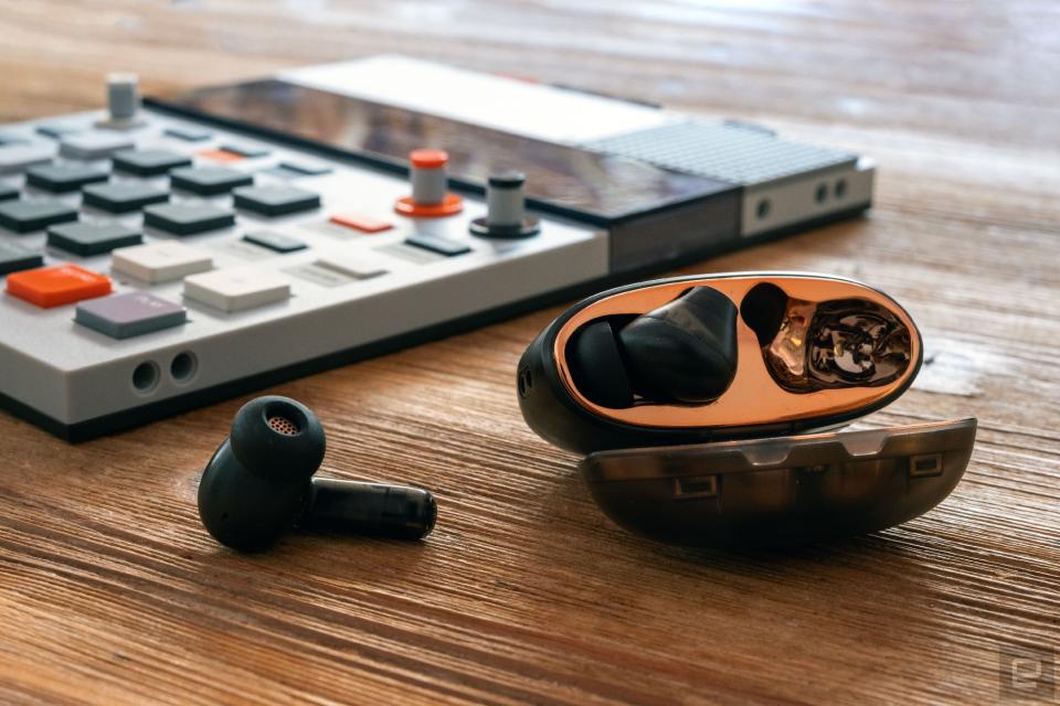 Creative Aurvana Ace headphones in their case next to a small synthesizer.