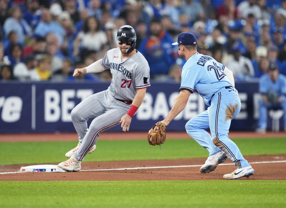 Minnesota Twins' Ryan Jeffers is safe at third on an infield single by Royce Lewis as Toronto Blue Jays third baseman Matt Chapman defends (26) during the 10th inning of a baseball game Friday, June 9, 2023, in Toronto. (Mark Blinch/The Canadian Press via AP)