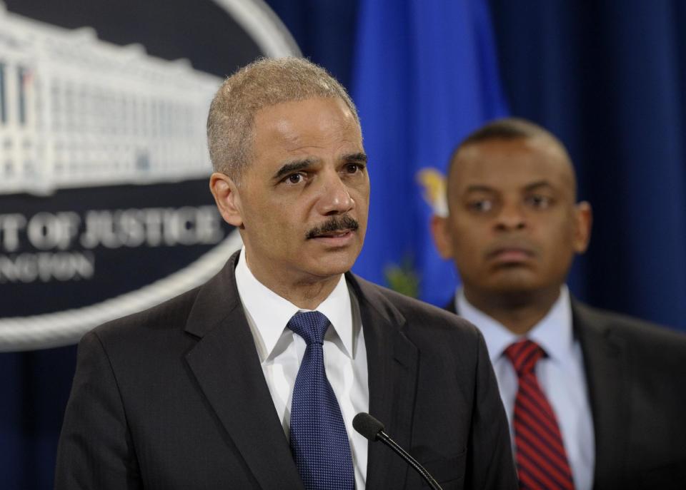 Attorney General Eric Holder, left, accompanied by Transportation Secretary Anthony Foxx, announces a $1.2 billion settlement with Toyota over its disclosure of safety problems, Wednesday, March 19, 2014, during a news conference at the Justice Department in Washington. (AP Photo/Susan Walsh)