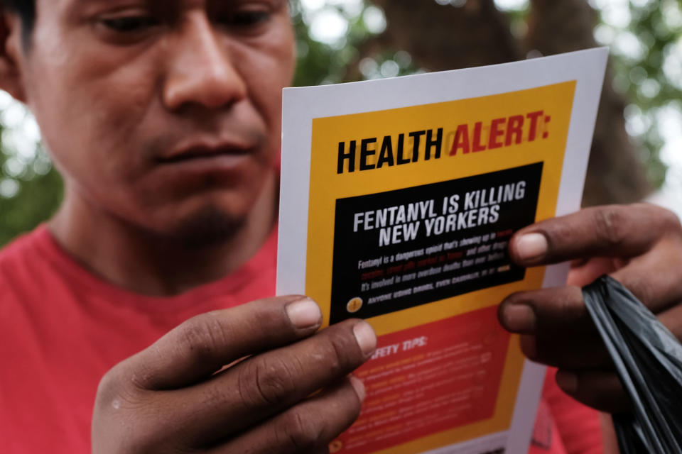 NEW YORK, NY - AUGUST 08:  A heroin user reads an alert on fentanyl before being interviewed by John Jay College of Criminal Justice students as part of a project to interview Bronx drug users in order to compile data about overdoses on August 8, 2017 in New York City. The Bronx was the borough with the highest number of overdose deaths in 2016 with 308 residents. The students interview their subjects in a park and ask questions about their history of drug use and if they have overdosed.The subjects receive a small financial compensation for the research.  (Photo by Spencer Platt/Getty Images)