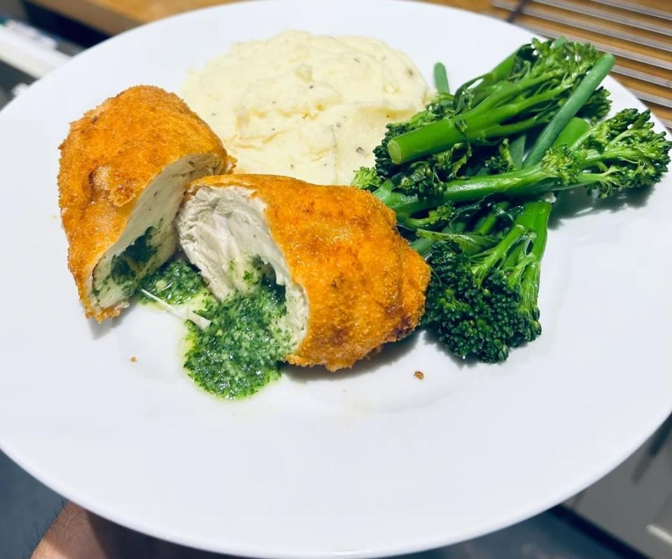 Chicken Kiev served with mashed potatoes and steamed broccoli on a white plate