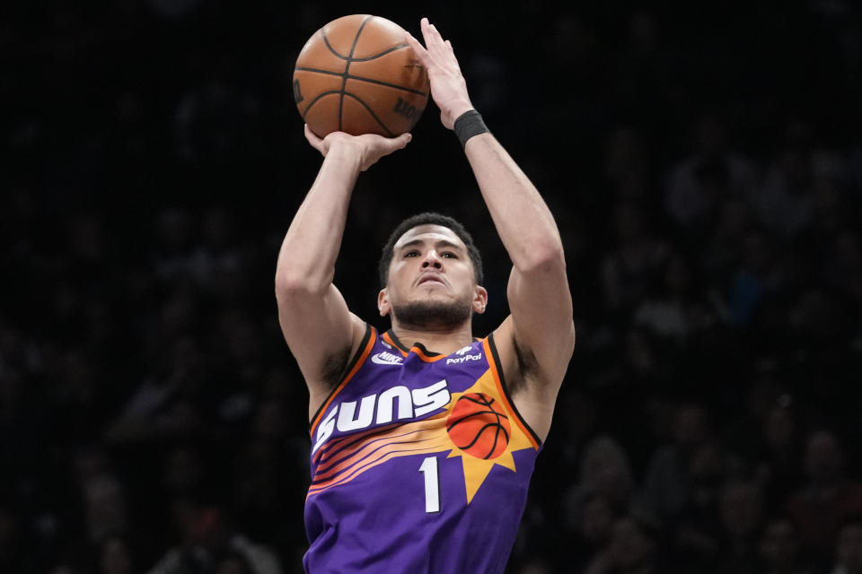 Phoenix Suns guard Devin Booker shoots a three-point basket during the second half of an NBA basketball game against the Brooklyn Nets, Tuesday, Feb. 7, 2023, in New York. The Suns won 116-112. (AP Photo/Mary Altaffer)