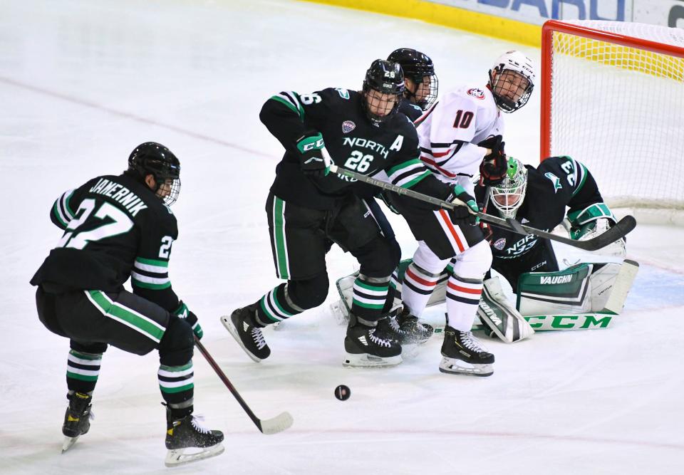 The puck bounces in front of North Dakota goaltender Zach Driscoll as St. Cloud State's Kyler Kupka puts on pressure during the first period of the game Saturday, Dec. 4, 2021, at the Herb Brooks National Hockey Center in St. Cloud.