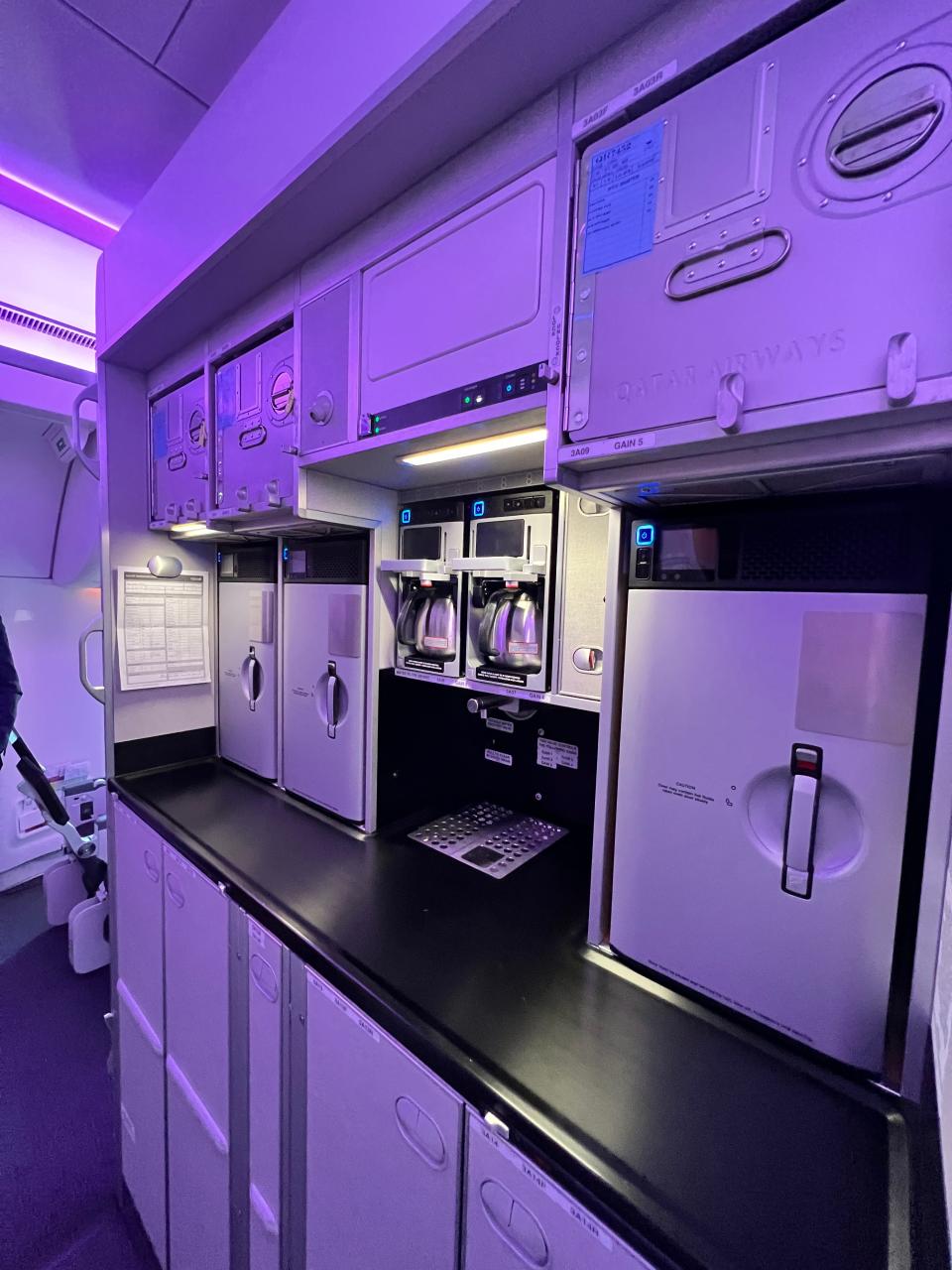 The galley, tinted purple due to lighting, on an Airbus A350