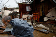 A man walks past a damaged house after the area was hit by Hurricane Maria in Guayama, Puerto Rico September 20, 2017. REUTERS/Carlos Garcia Rawlins