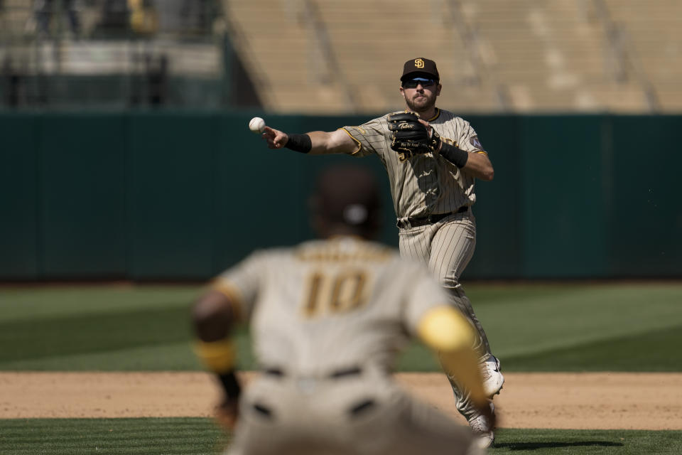 San Diego Padres second baseman Matthew Batten, top, throws to first baseman Jurickson Profar, foreground, for an out against Oakland Athletics' Nick Allen during the fifth inning of a baseball game Sunday, Sept. 17, 2023, in Oakland, Calif. (AP Photo/Godofredo A. Vásquez)