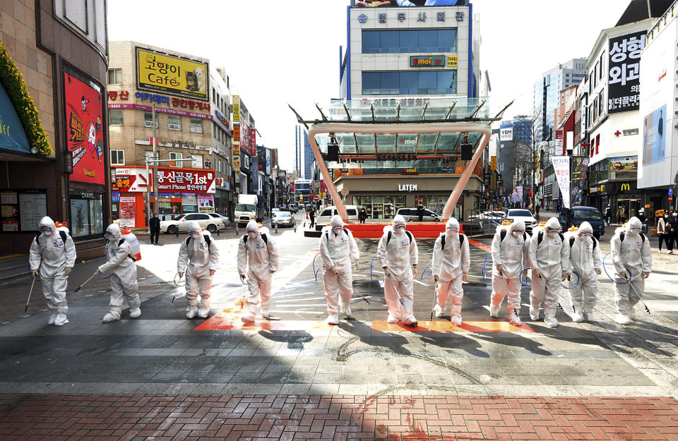 Soldados surcoreanos con vestimenta protectora rocían desinfectante para impedir la propagación del virus del COVI-19 en una calle en Dargu. Corea del Sur, jueves 27 de febrero de 2020. (Lee Moo-ryul/Newsis via AP)