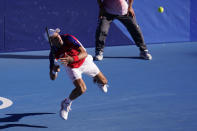 Novak Djokovic, of Serbia, returns a shot to Pablo Carreno Busta, of Spain, during the bronze medal match of the tennis competition at the 2020 Summer Olympics, Saturday, July 31, 2021, in Tokyo, Japan. (AP Photo/Seth Wenig)