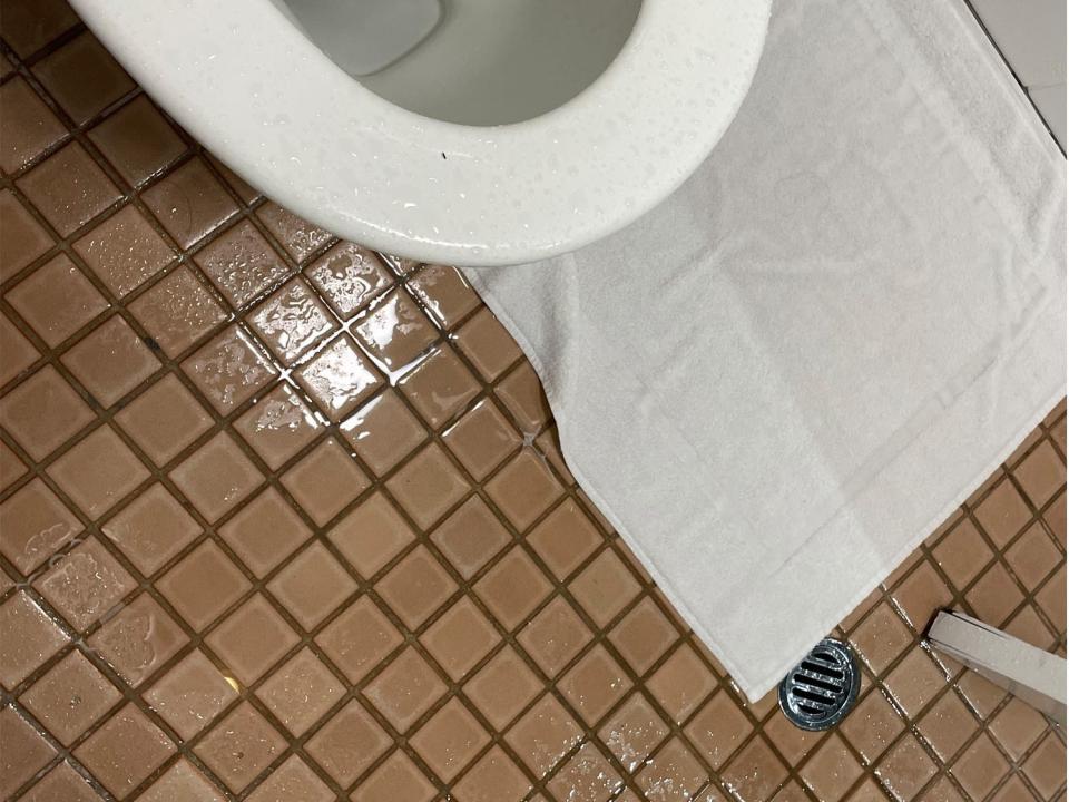 The toilet and bed in the hotel room