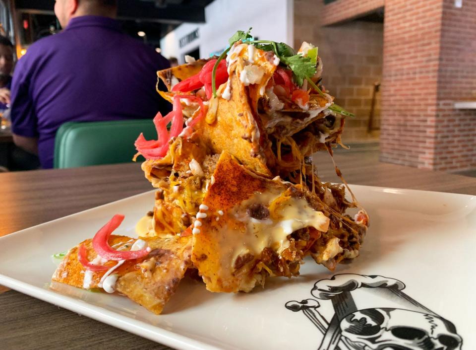Trash can nachos are a Guy Fieri original, with smoked pork, black beans and bourbon brown sugar barbecue sauce.