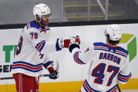 New York Rangers defenseman K'Andre Miller (79) is congratulated by Morgan Barron (47) after his goal during the second period of an NHL hockey game against the Boston Bruins, Saturday, May 8, 2021, in Boston. (AP Photo/Charles Krupa)