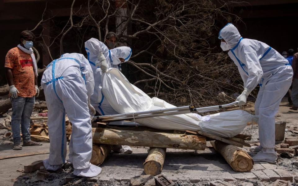 Family members prepare the body of a relative for cremation in New Delhi - Reuters