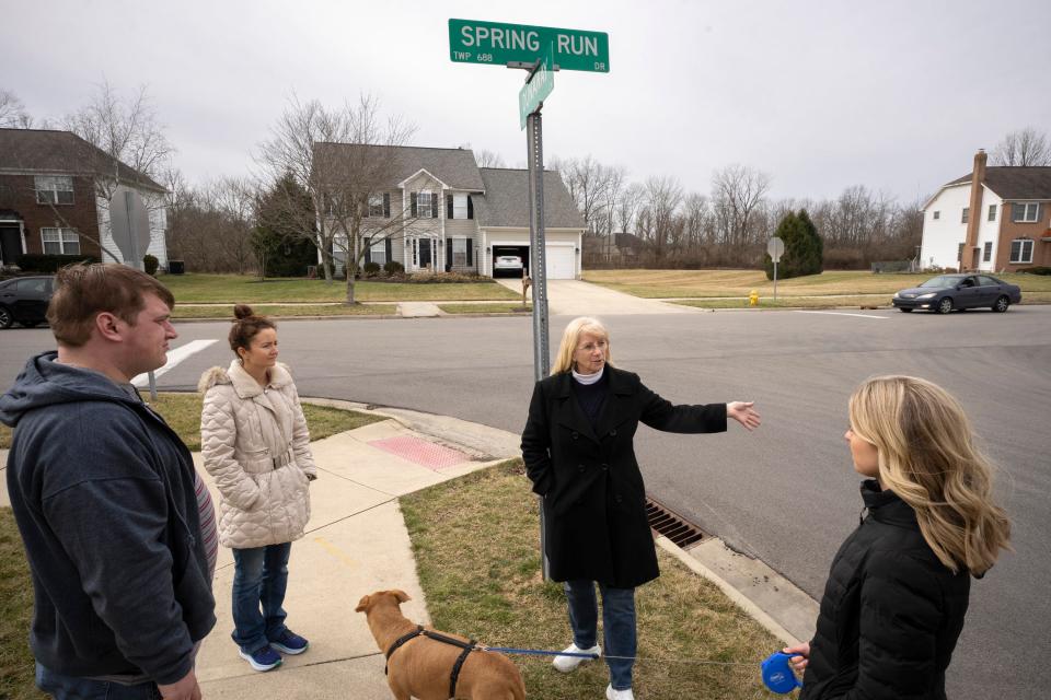 Debbie Bever, second from right, discusses with other community members the planned removal of stop signs from the intersection of Spring Run Drive and Dunaway Lane in Genoa Township.